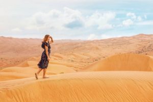 Woman Searching (for a Functional Medicine Approach) While Walking on the Sand